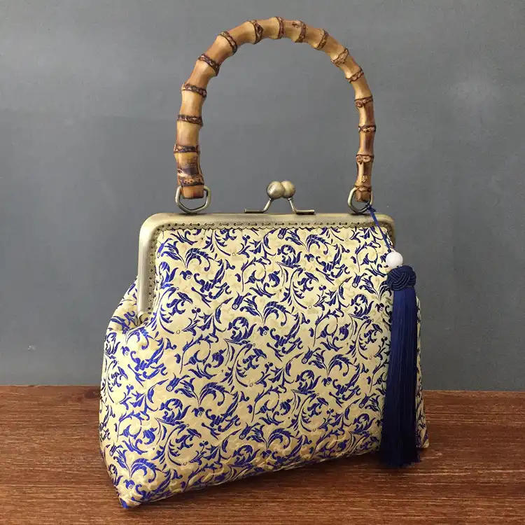 Elegant silk embroidery bag with Chinese cheongsam floral design on white background.
