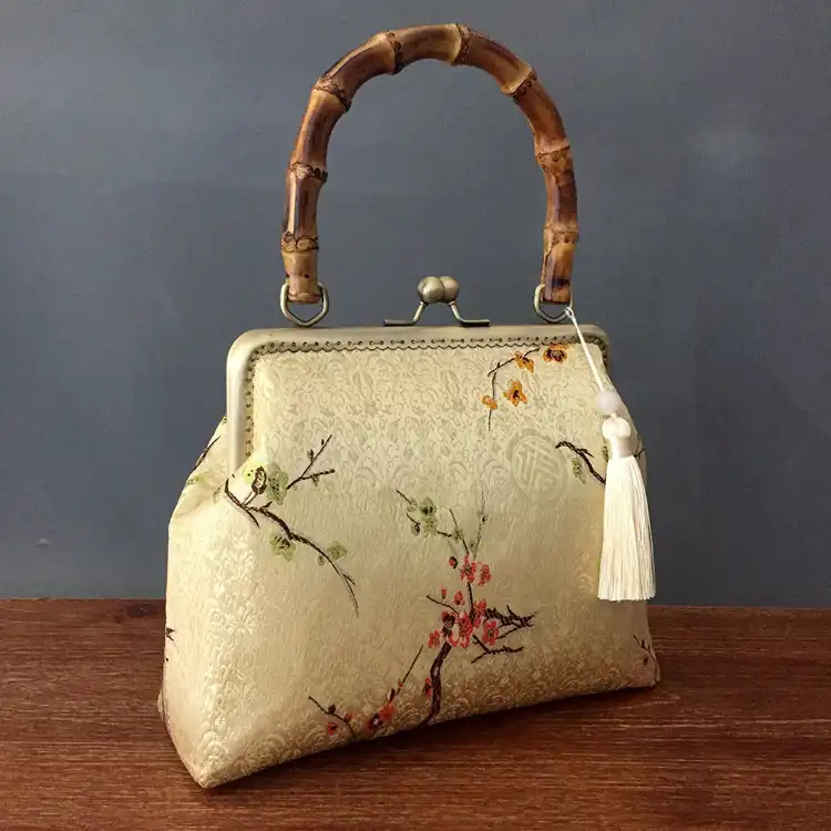 Lifestyle shot of embroidery bag paired with cheongsam dress outfit.