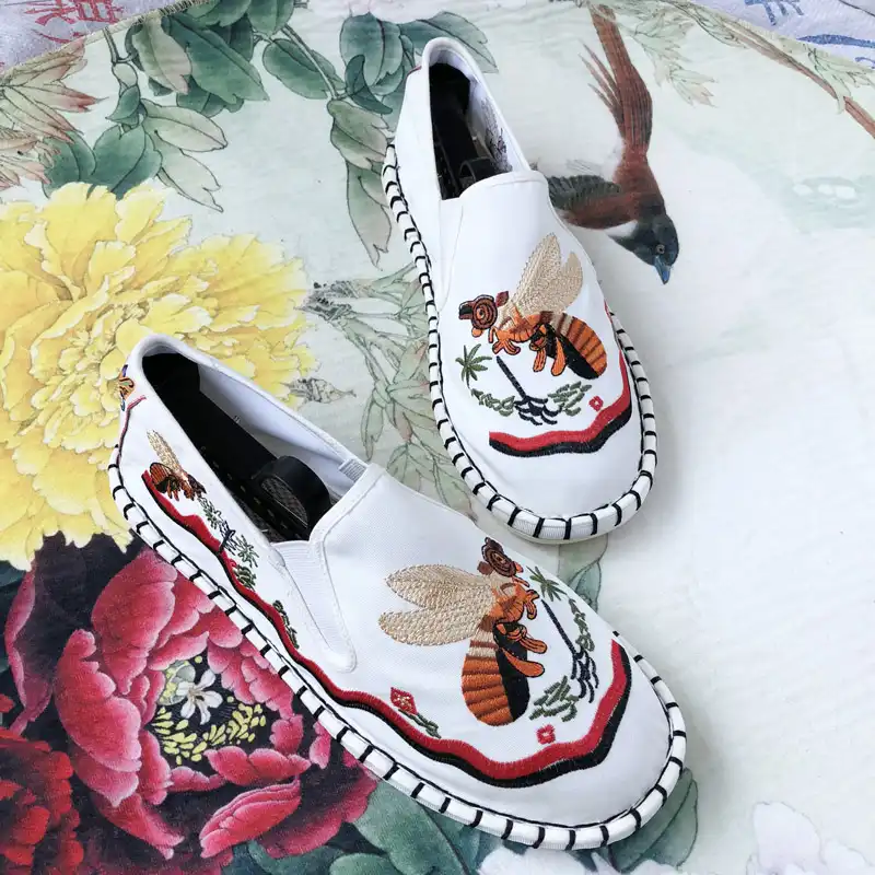 Traditional embroidered flats displayed with Chinese cultural accessories and decorations.