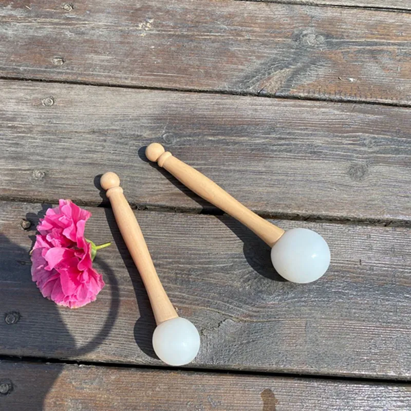 Rubber mallet striking crystal bowl demonstrating clear tone production for sound healing.