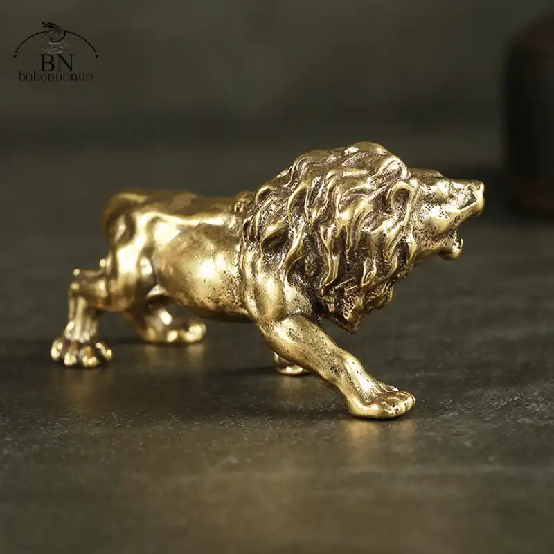 Desktop setting with bronze lion ornament positioned next to books and office accessories.