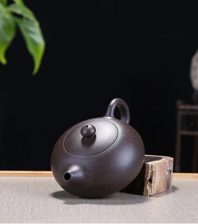 Dahongpao tea brewing process using Xishi teapot showing golden tea color and clear liquid flow.