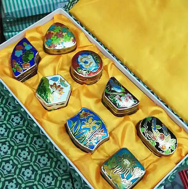 Close-up view of cloisonne enamel work showing detailed floral motifs and vibrant colors.
