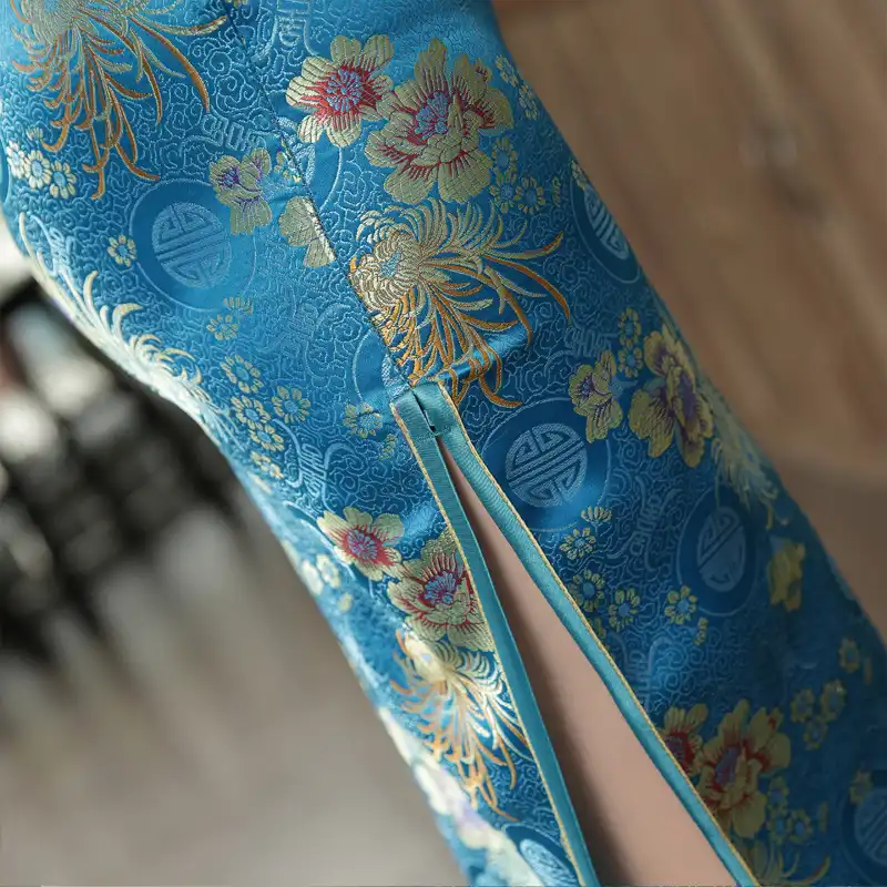 Model in green qipao dress showing movement and fabric flow during formal event.