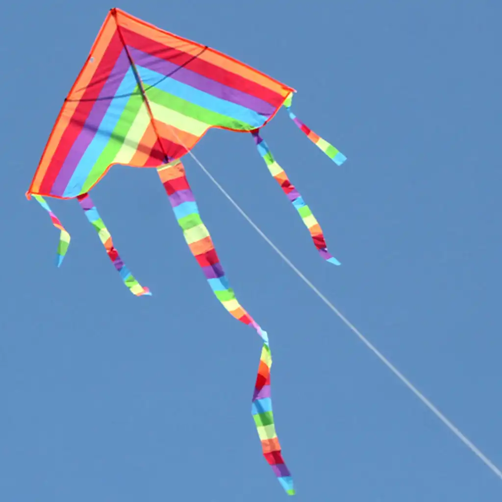 Rainbow triangle kite soaring against clear blue sky demonstrating stable flight performance.