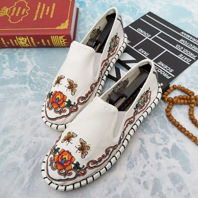 Pair of traditional Chinese women's loafers on white background showing rubber outsole.