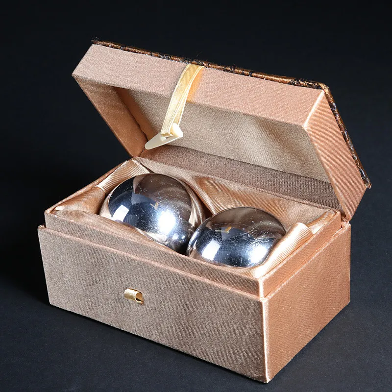 Jade fitness balls meditation setup on wooden surface showcasing traditional Chinese wellness practice.