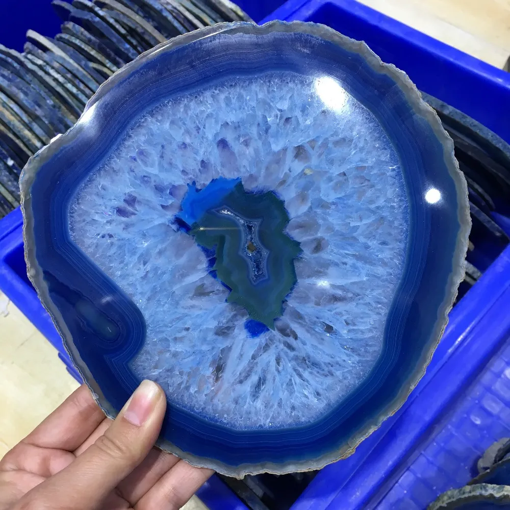 Large blue agate slice comparison with hand showing impressive 150mm dimensions.