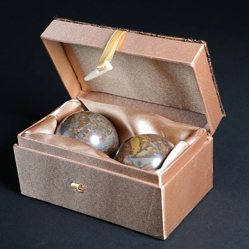Close-up of natural jade Baoding balls highlighting smooth surface finish and beautiful green stone patterns.