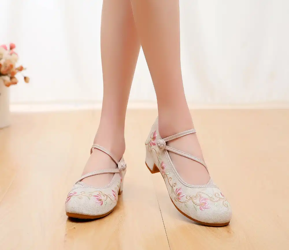 Handmade embroidered kung fu pumps on wooden floor showing authentic craftsmanship quality.