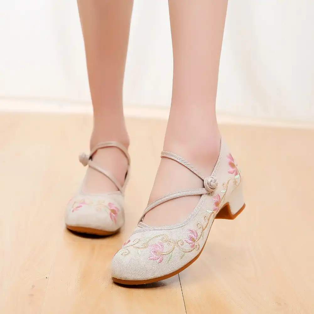 Medium heel pumps photographed from above showing symmetrical embroidered design pattern.