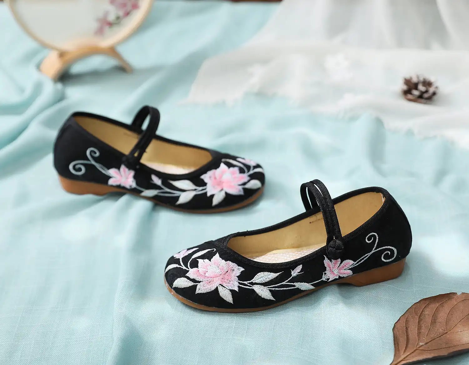 Close-up detail of intricate flower embroidery pattern on cotton canvas upper showing cultural artistry.