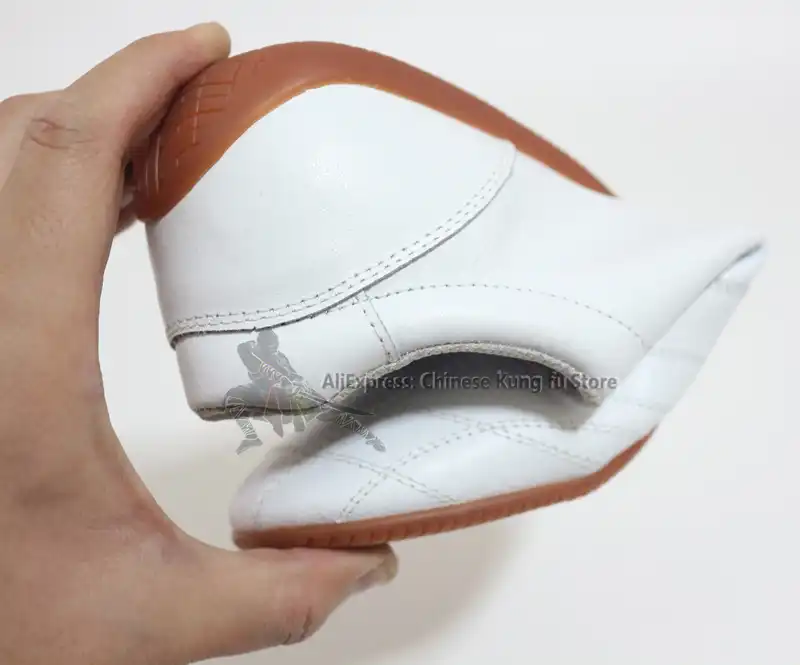 White leather kung fu shoes with traditional embroidered Chinese characters meaning martial arts.