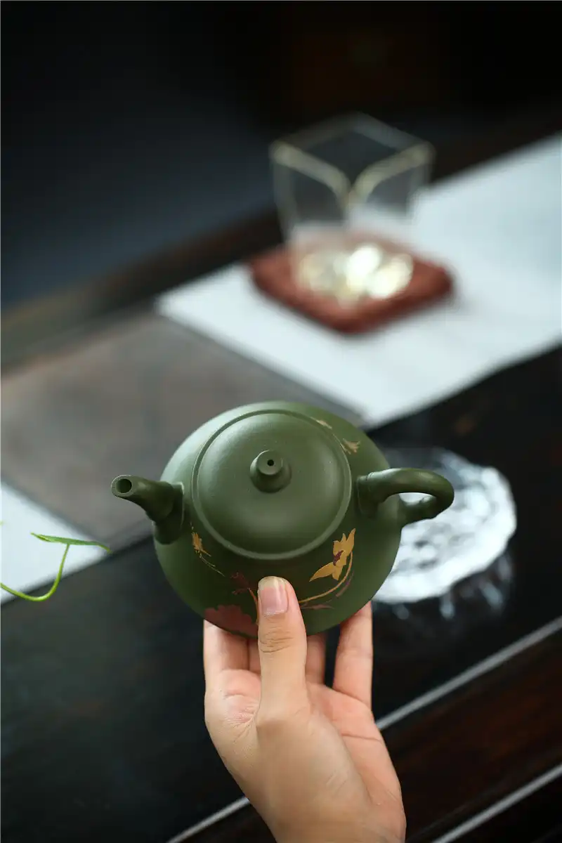 Traditional Chinese teaware display featuring authentic green kettle Kung Fu brewing vessel.