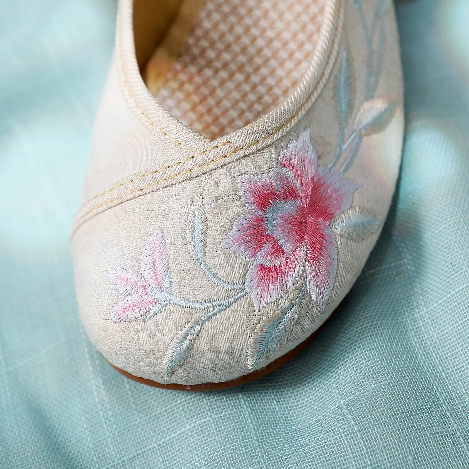 Flower embroidered flats photographed from above displaying symmetrical floral pattern design.
