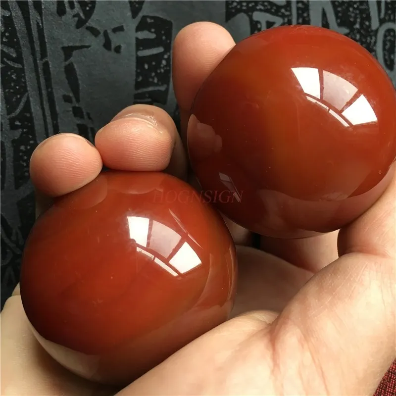 Hands demonstrating proper Baoding ball rotation technique for stress relief and hand exercise.