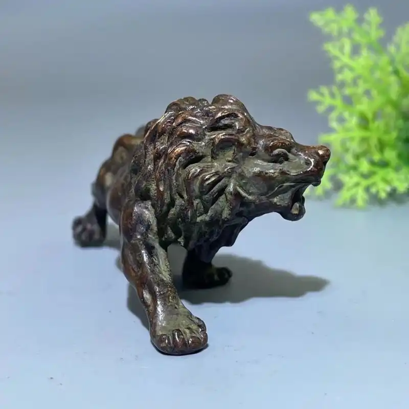Miniature lion statue in garden setting showcasing versatile decorative placement options.