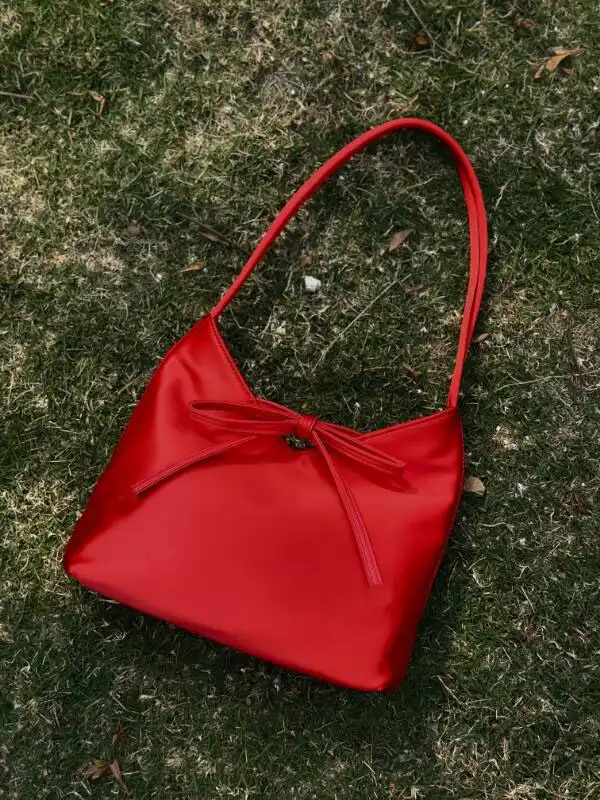 Red silk satin handbag with elegant butterfly bow decoration and square shape design.