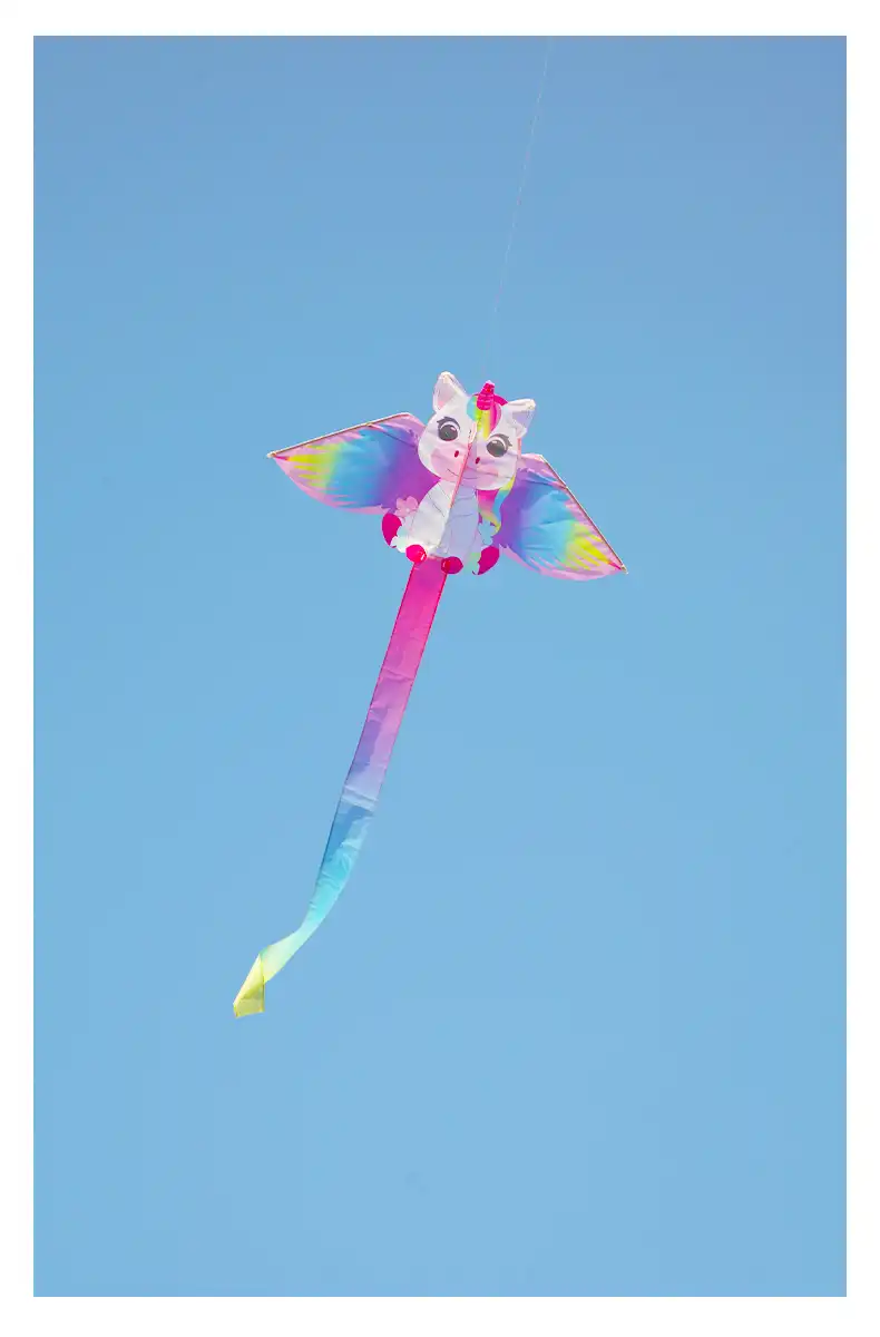 Pink unicorn kite soaring high against cloudy sky demonstrating stable flight performance.