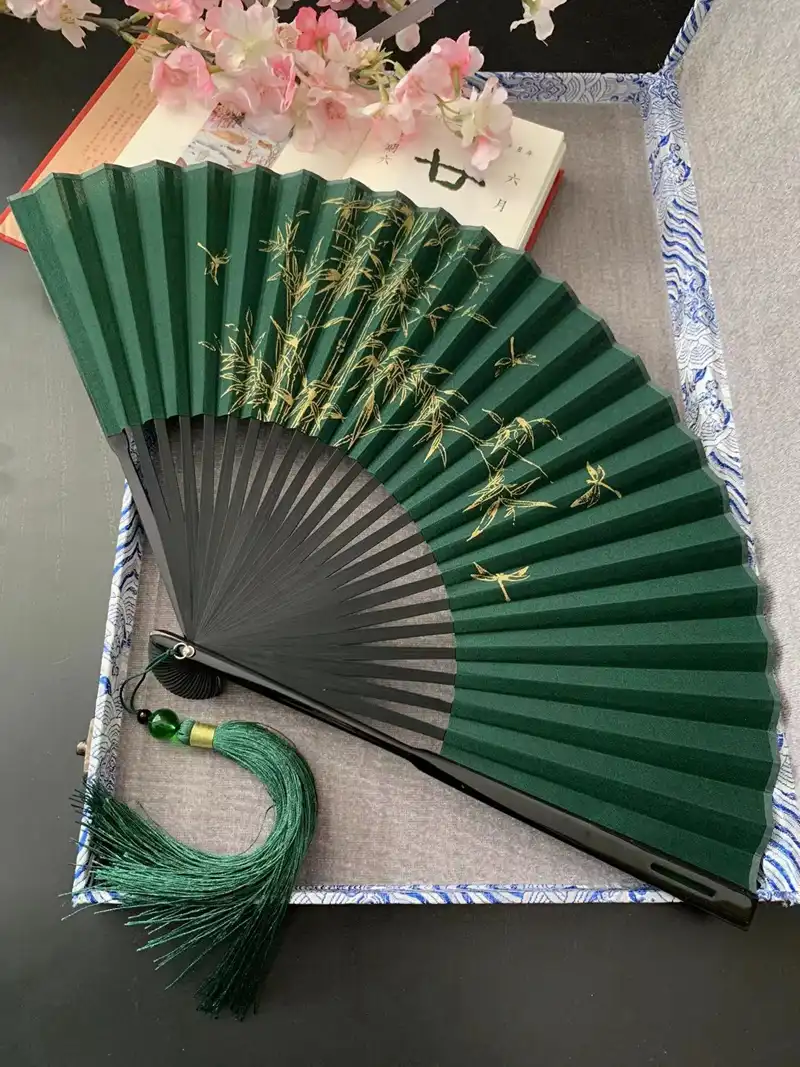 Retro style mens folding fan with dark green background and botanical print design.