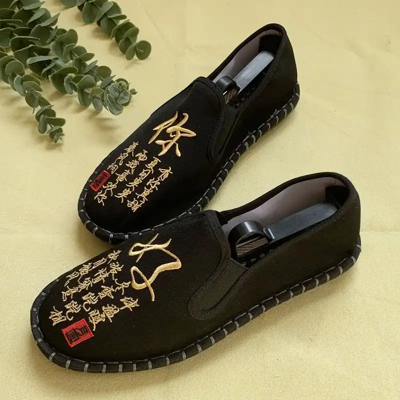 Close-up detail of intricate animal print embroidery pattern on traditional Chinese streetwear shoes.