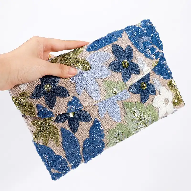 Straw envelope clutch bag with embroidered floral pattern and sequin decoration.