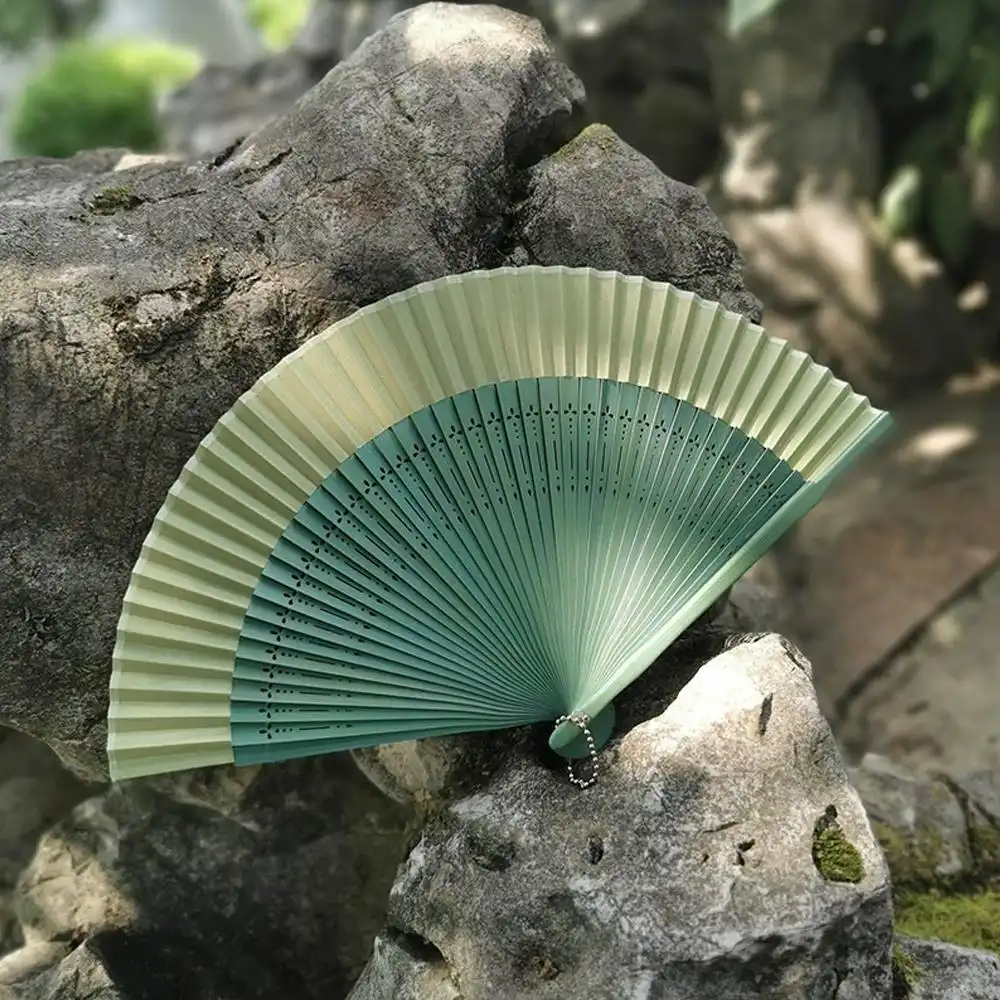 Color transformation demonstration of folding fan under different lighting conditions.