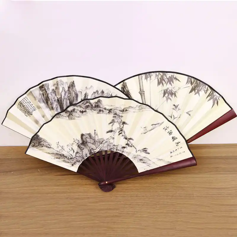 Size comparison of folded fan next to common objects demonstrating portable compact dimensions.