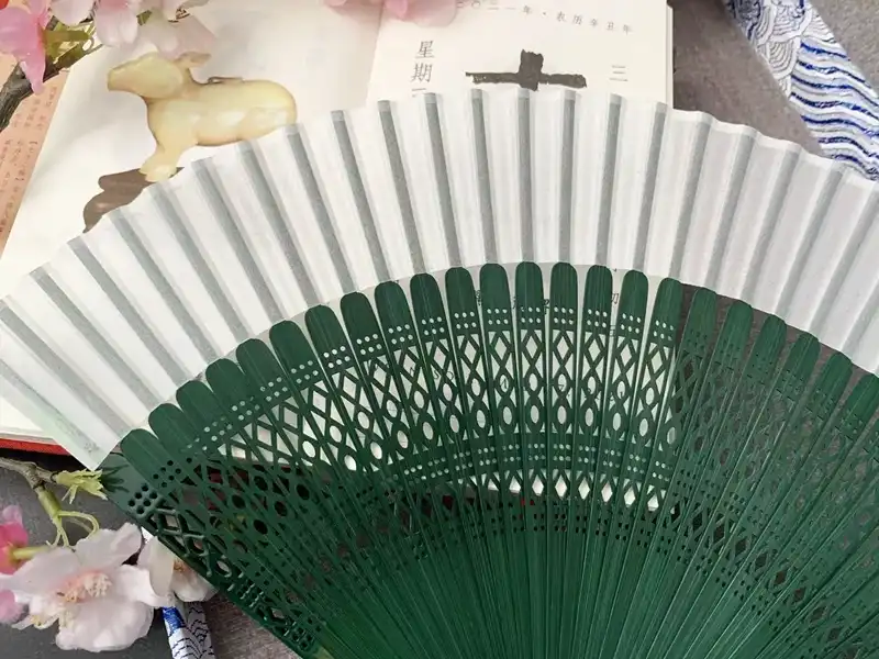 Japanese ancient style dance fan with green bamboo ribs displayed fully open showing traditional design.