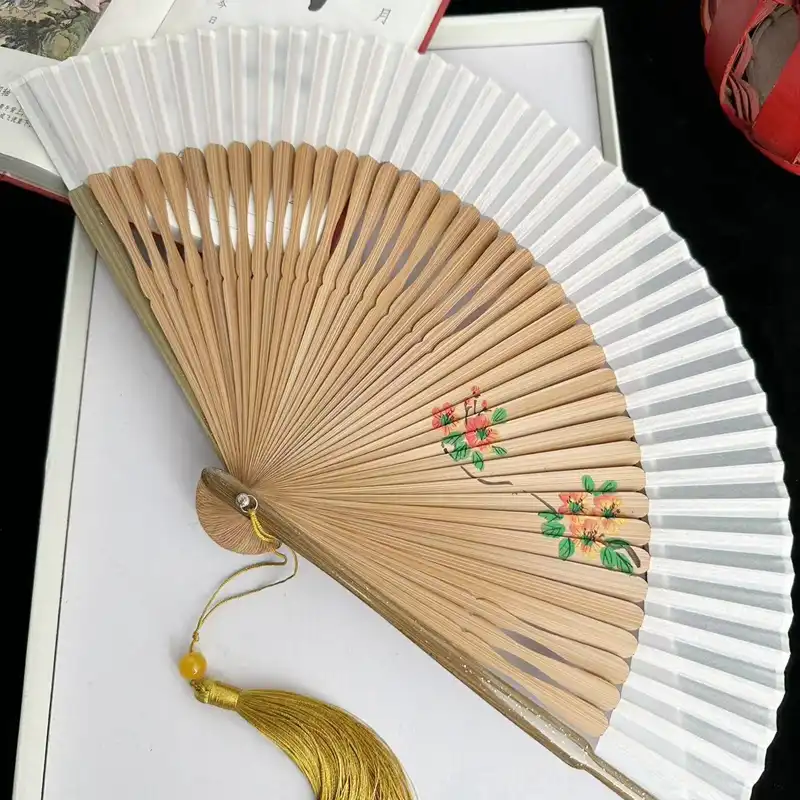 Summer outdoor setting with woman using portable dragonfly fan for cooling and style.