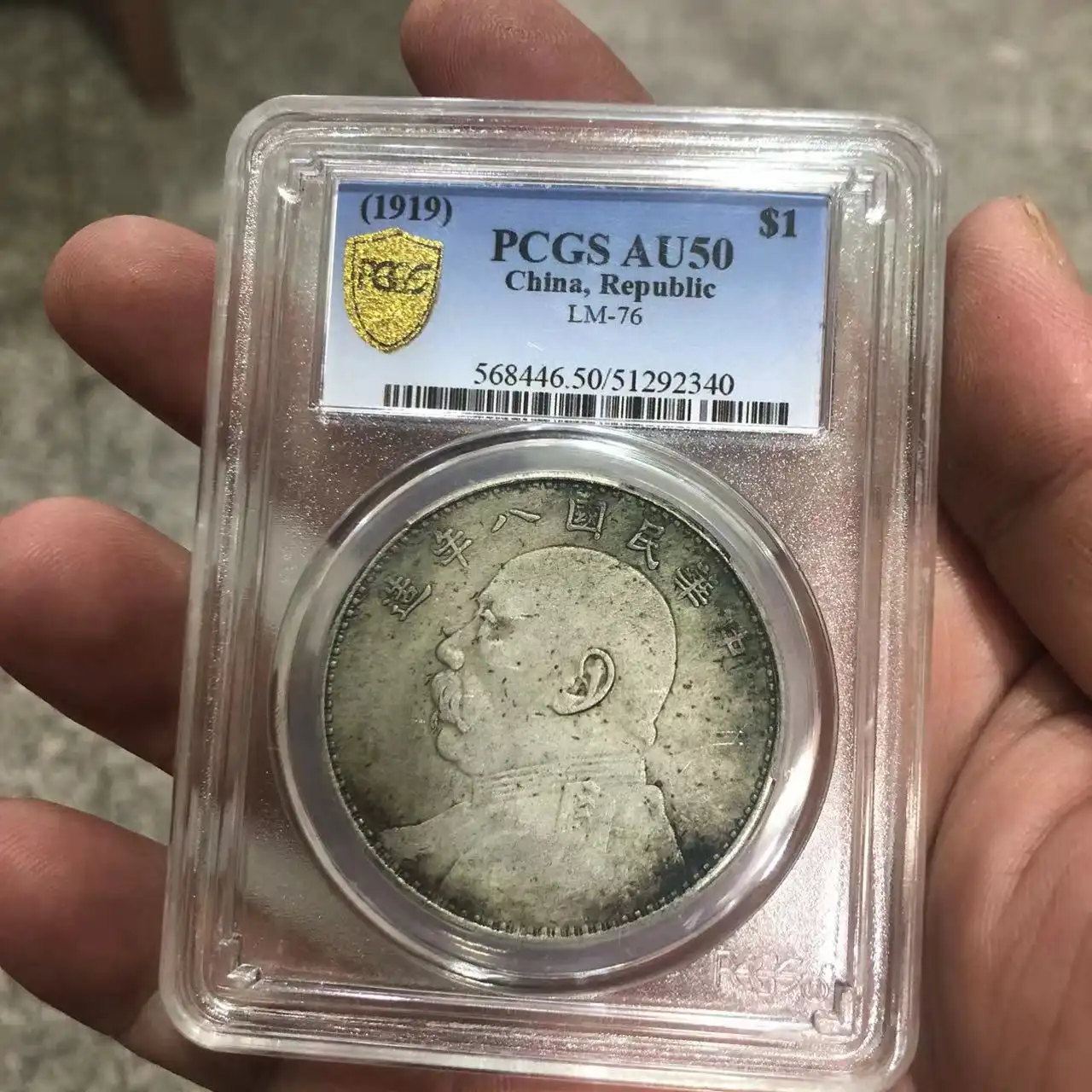 Antique Chinese silver dollar yuan big head coin displayed with PCGS certification box.