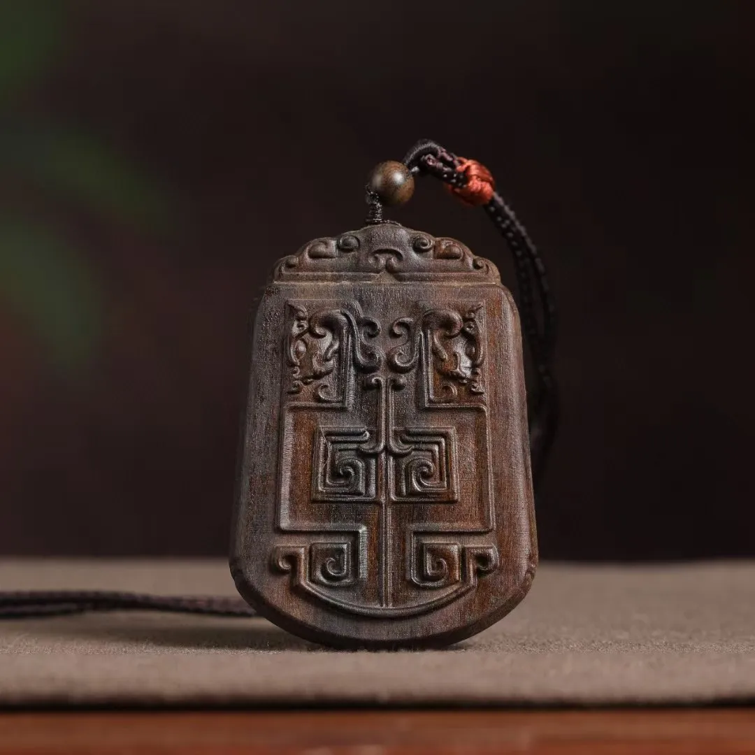 Handcrafted agarwood car hanging pendant showing double-sided antique pattern carving details.