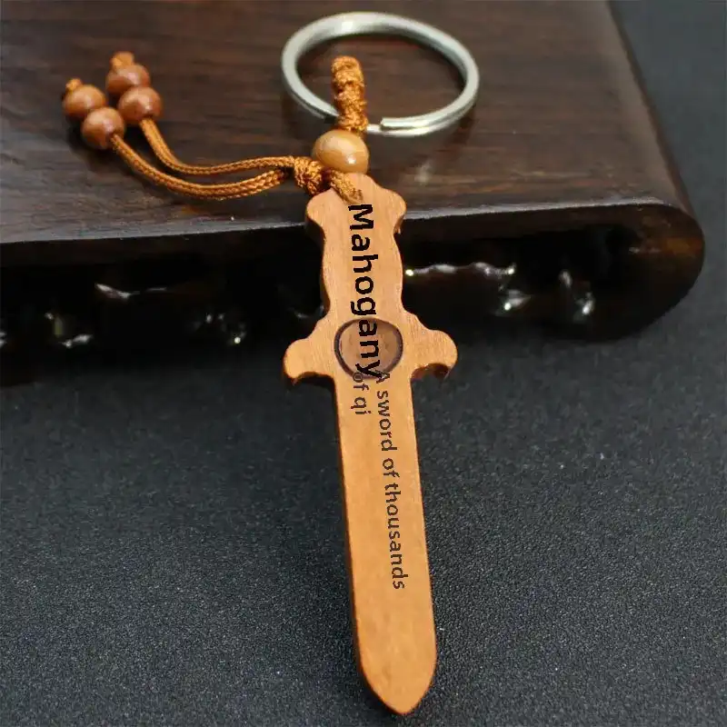 Peach wood sword keychain attached to car keys demonstrating practical automotive accessory use.