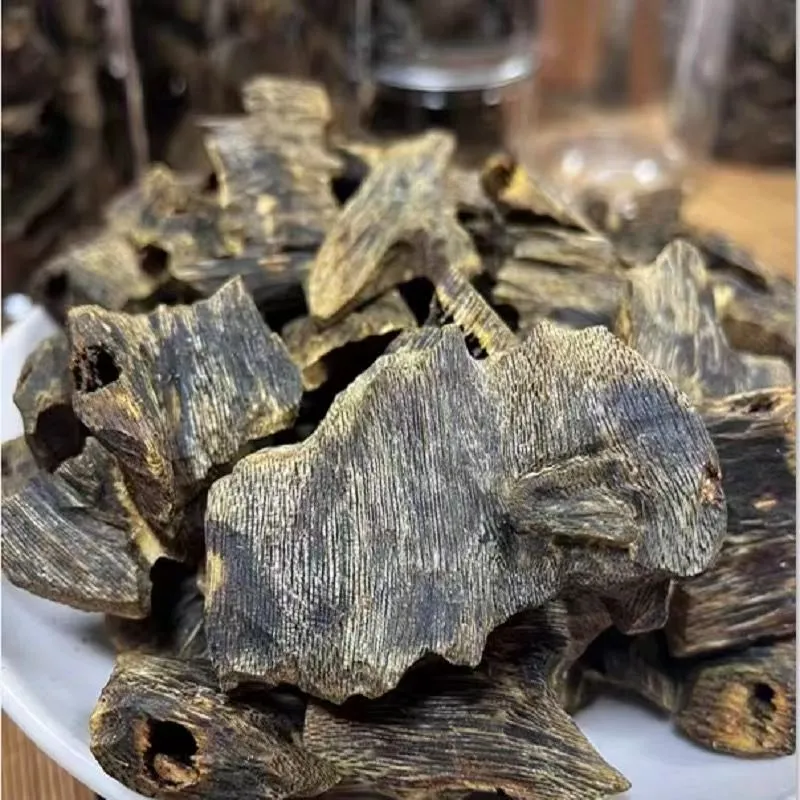 ​​Agarwood chips burning in traditional incense burner creating aromatic smoke for meditation.