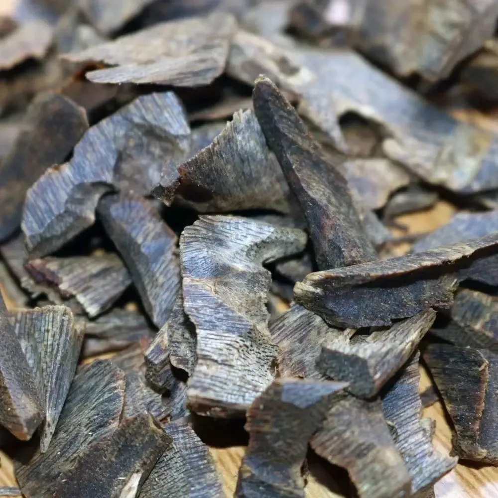 ​​Vietnam oud chips burning on traditional incense burner creating aromatic smoke for meditation.