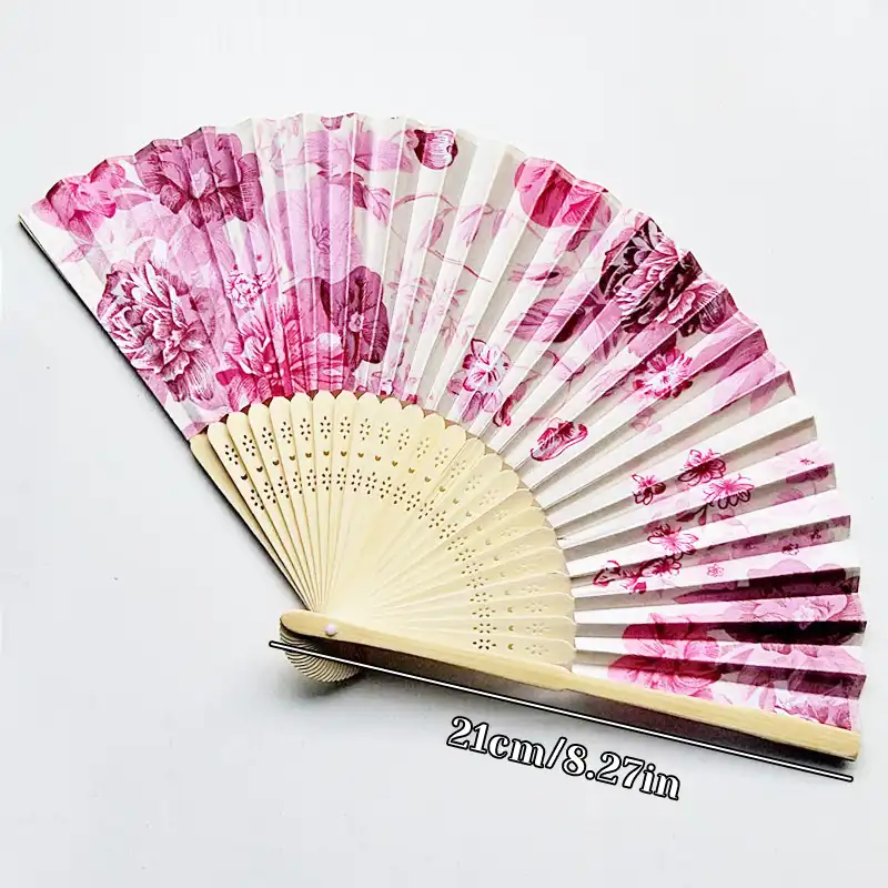Model holding silk flower pattern fan demonstrating elegant hand positioning and proper grip.