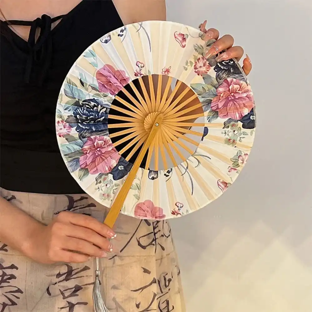 Round windmill Chinese hand fan closed showing bamboo handle and compact folding design for portability.