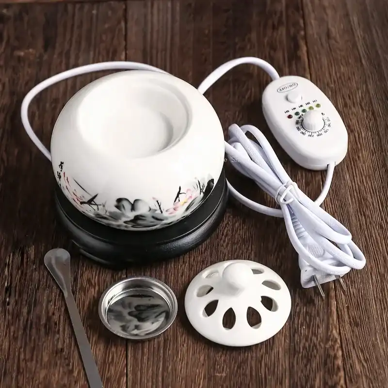 White ceramic electric incense burner with temperature control dial and timer display on desk.
