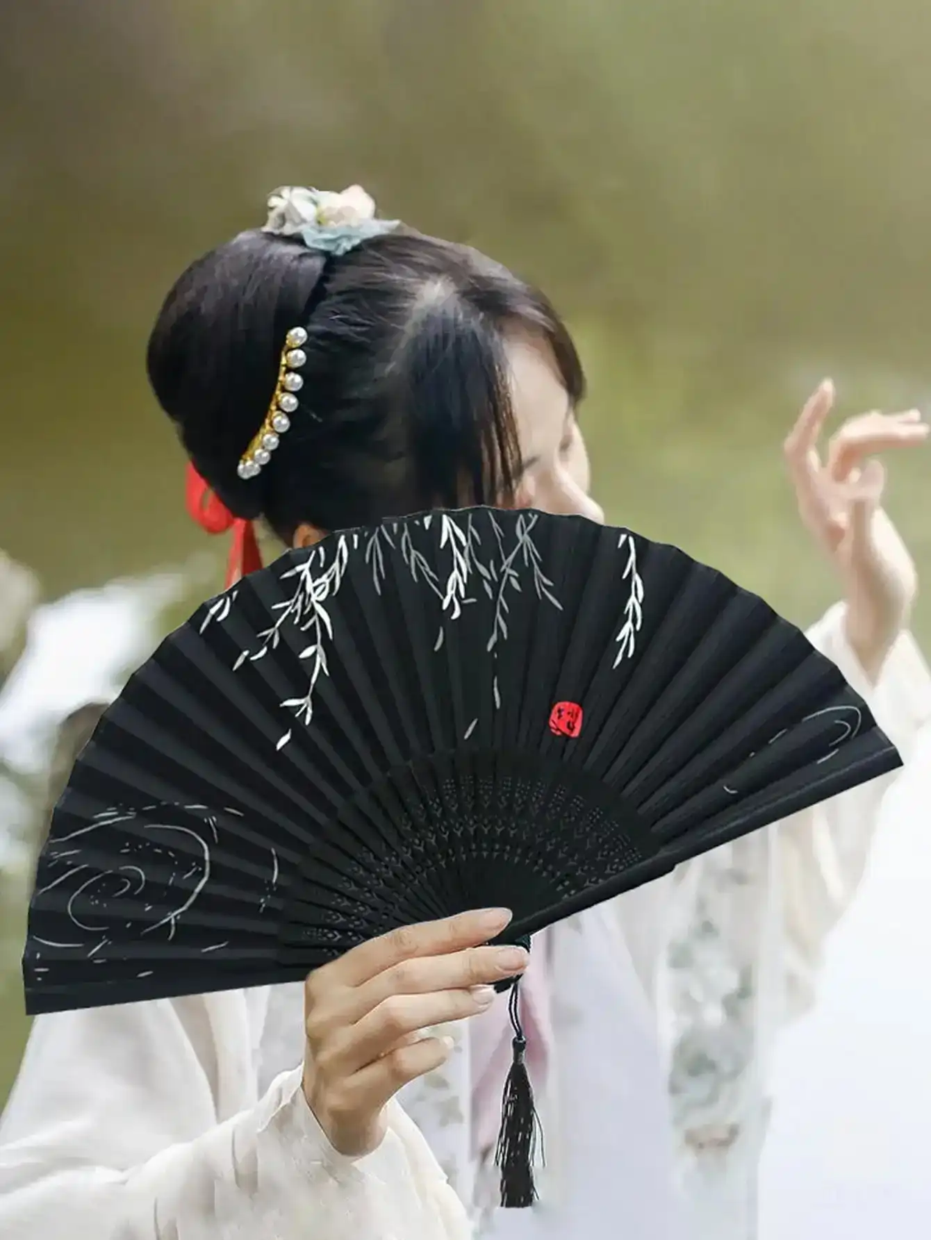 Closed wooden folding fan showing compact size and premium wood construction quality.