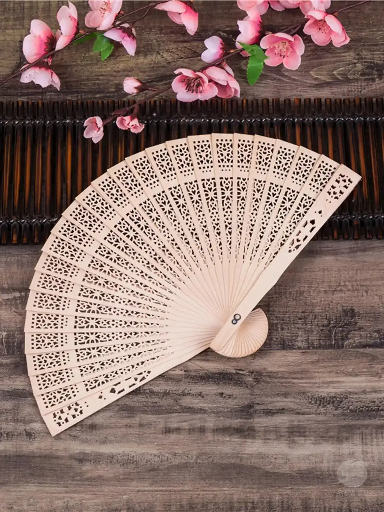 Side view of folding fan displaying wood frame structure and fabric attachment.