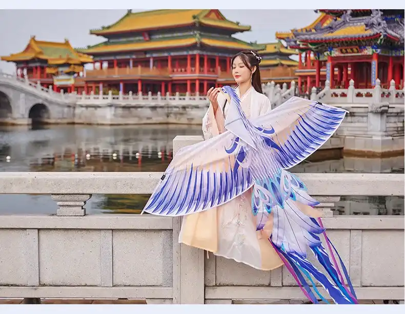 Phoenix kite in flight with colorful tail streamers flowing behind showing graceful movement.