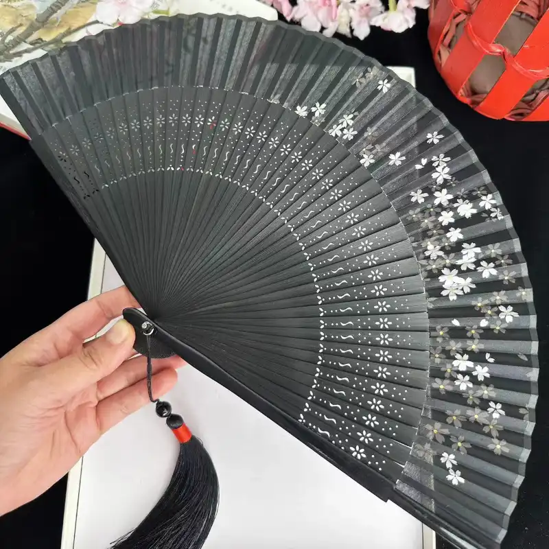 Model holding dragonfly fan demonstrating one-handed opening and elegant feminine styling.