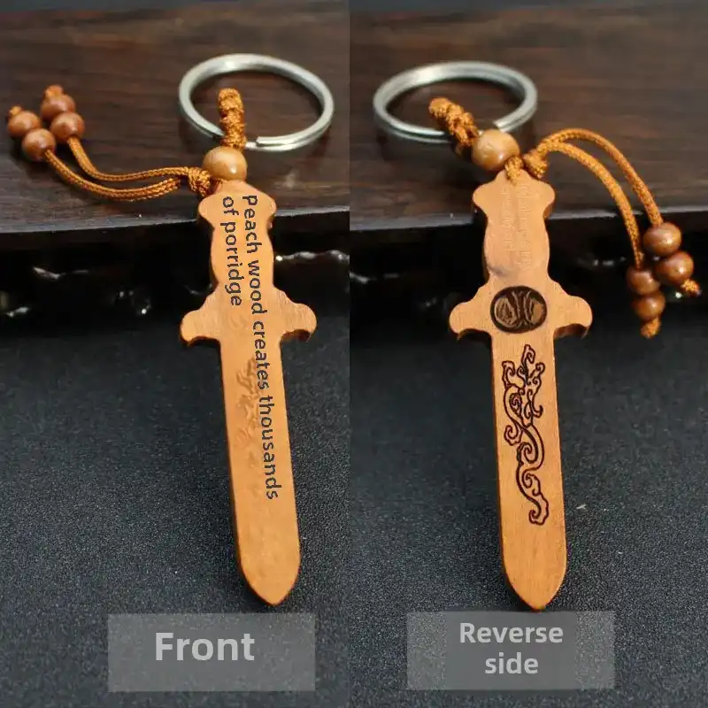 Close-up detail of engraved wooden sword keychain showing traditional craftsmanship and texture.