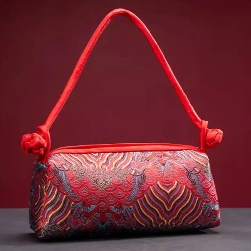 Black silk embroidered evening handbag featuring sophisticated floral embroidery work details.