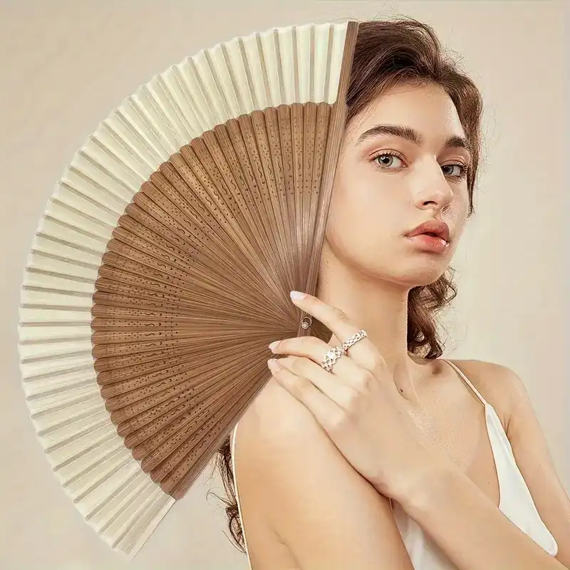 Heart shaped bamboo folding fan opened displaying white paper blades and wooden frame construction.