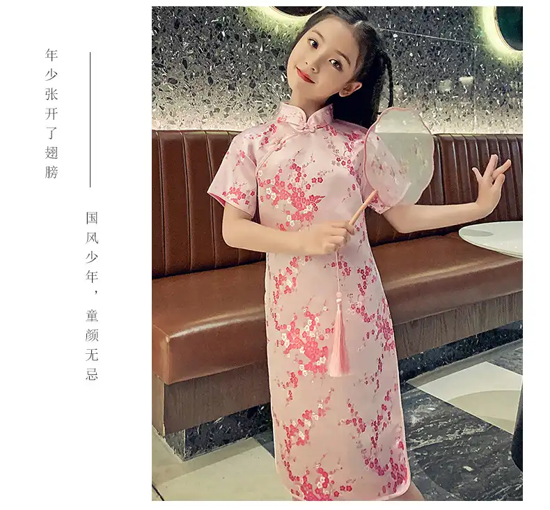 Modern cheongsam dress for girls in green with beautiful embroidered details visible.