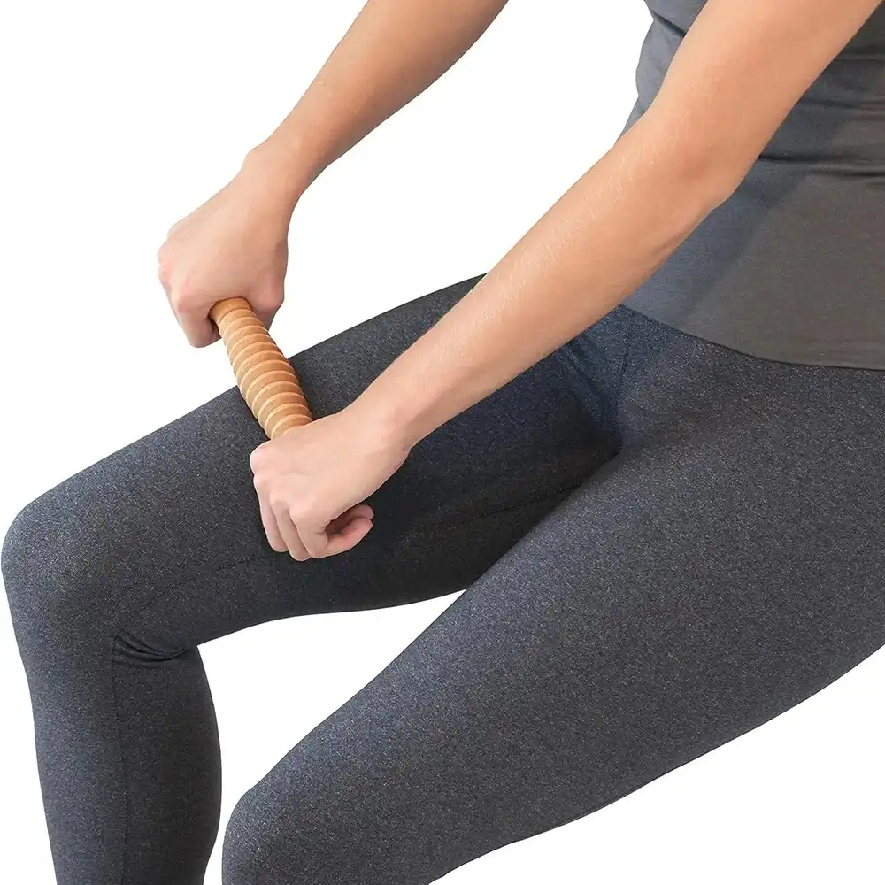 Wooden massager for foot arch pain, used under desk..