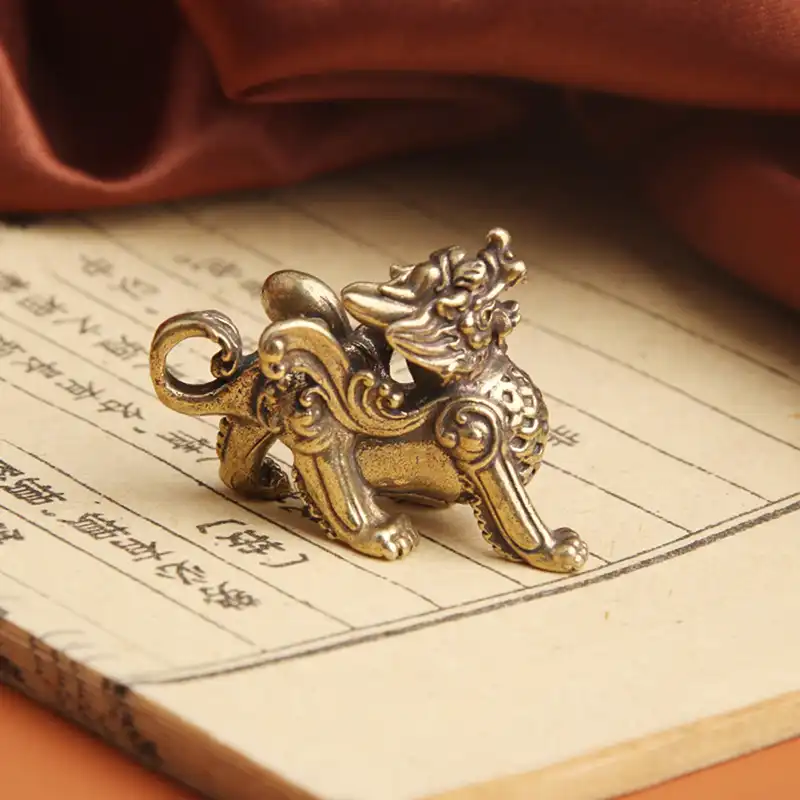 Close-up view of brass Kylin figurine head featuring intricate dragon-like features and scales.
