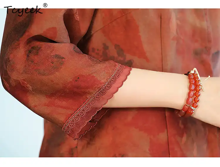 Close-up detail of intricate red floral embroidery on authentic Xiangyunsha silk fabric.