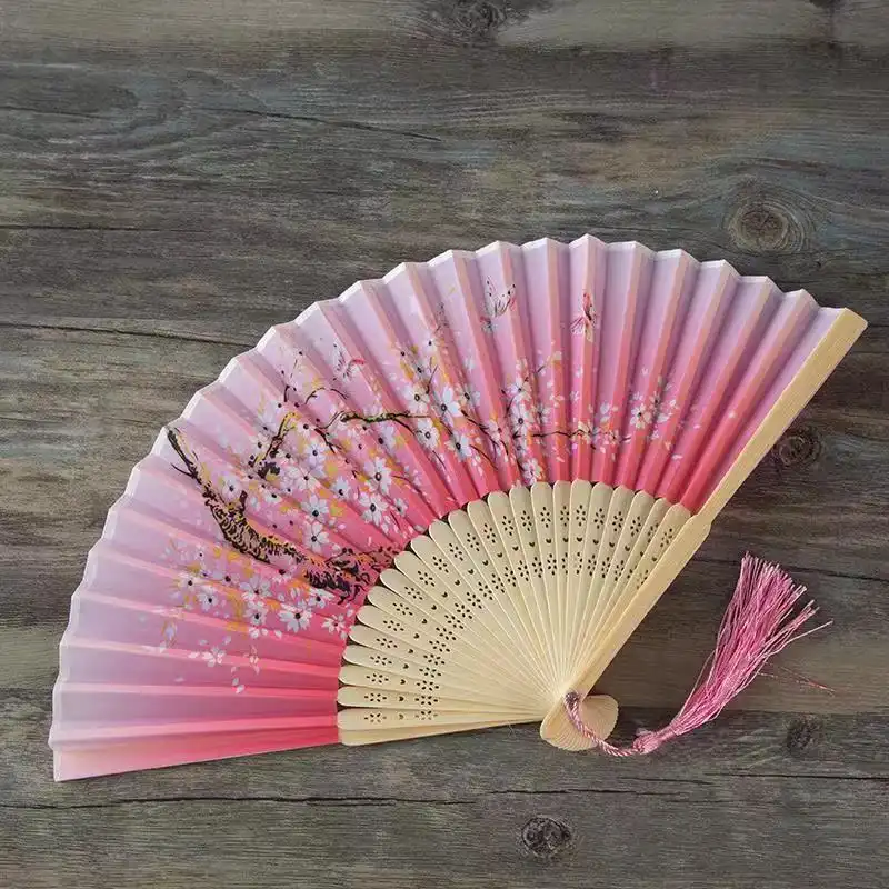 Home decoration display featuring folding fan mounted on wall as artistic element.